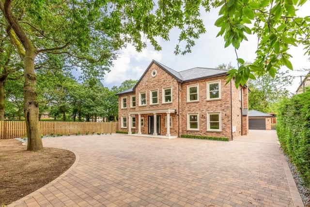 Electric gates open to the wide driveway and impressive frontage of the six-bedroom home.