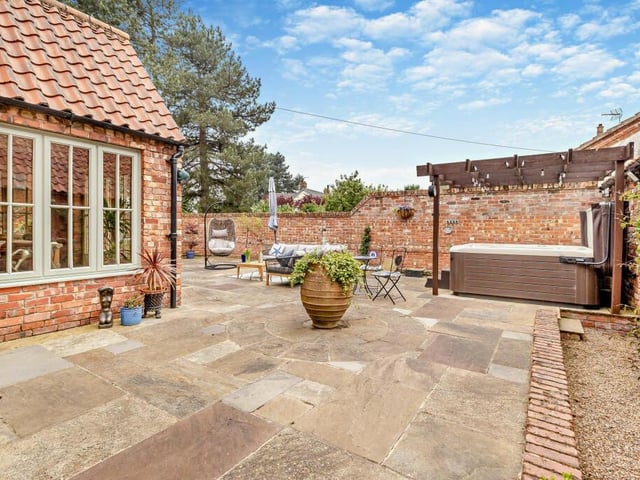 Outdoor facilities include space for a hot tub and pergola.