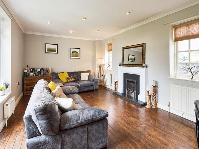 A versatile sitting or family room with doors out to a balcony with glass balustrade.
