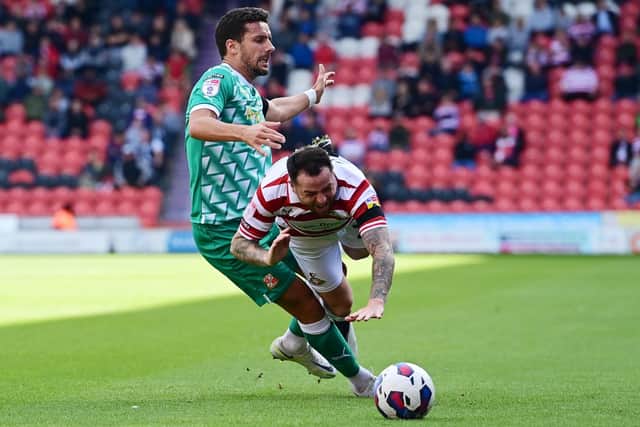 Doncaster's Lee Tomlin is brought down by Swindon's Mathieu Baudry.