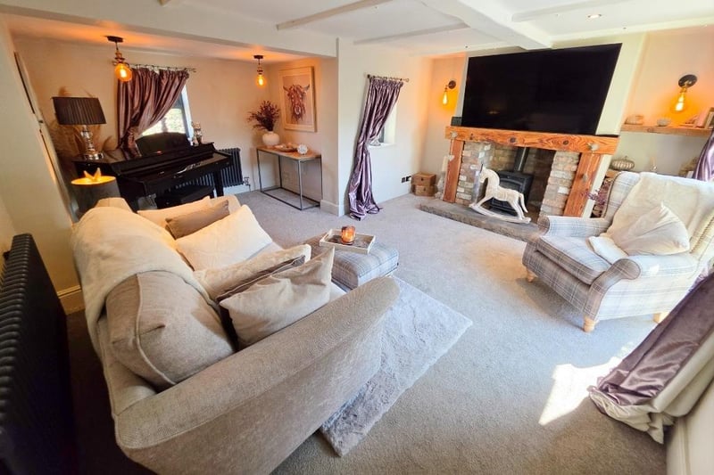 A rustic style fireplace with log burner takes centre stage in the beamed lounge, that has French doors out to the garden patio.