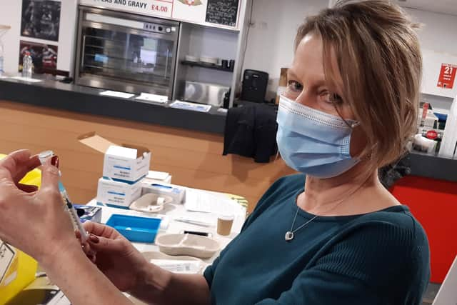 A volunteer prepares a vaccine at a Doncaster vaccination centre