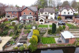 The rear tiered garden stretches down to the canal, where the property has mooring rights.