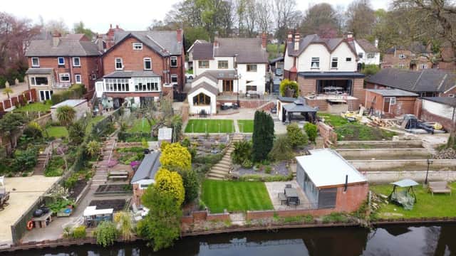 The rear tiered garden stretches down to the canal, where the property has mooring rights.