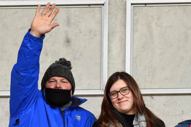 A Dons fan waves for the camera. Photo: Andrew Roe/AHPIX LTD