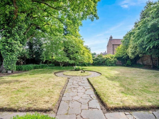 The rear garden is private and enclosed with mature trees and shrubs.