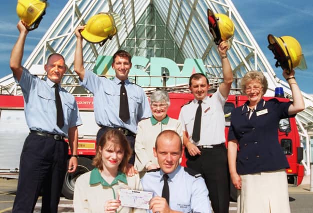 Checkout girl Jane Proctor presented a cheque for £100 to Andy Eaton to help fund a victim support unit back in 1997