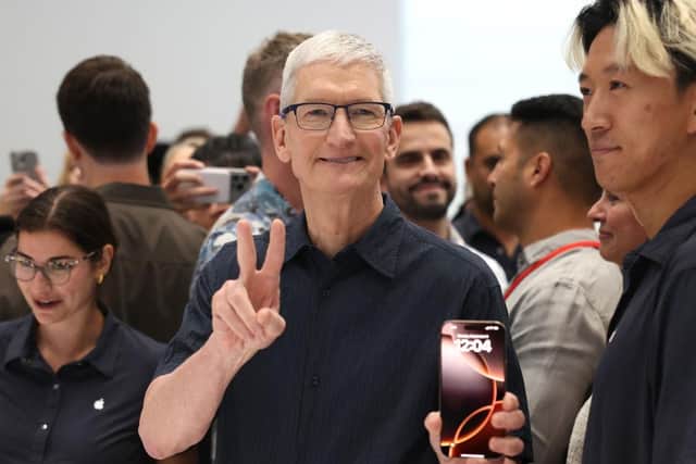 Apple CEO Tim Cook inspects the new iPhone 16 during an Apple special event at Apple headquarters (Photo by Justin Sullivan/Getty Images)