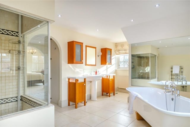 This bathroom includes a free standing bath, and shower cubicle within its suite.