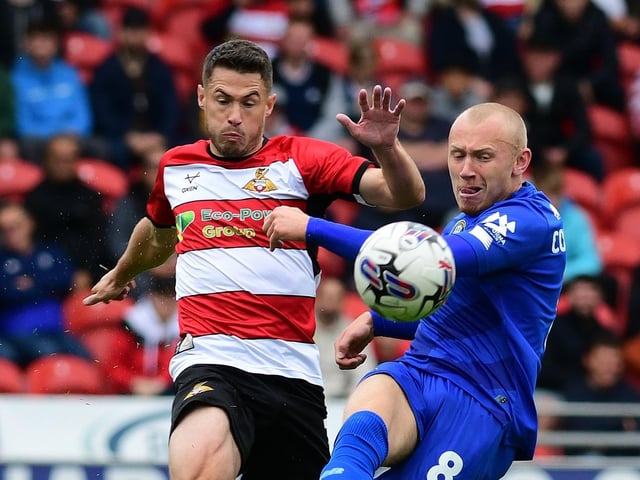 Doncaster Rovers' Tommy Rowe battles for the ball with Harrogate Town's Dean Cornelius.