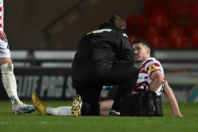 Doncaster's Tommy Rowe receives treatment from the club's new physio Karl Blenkin.