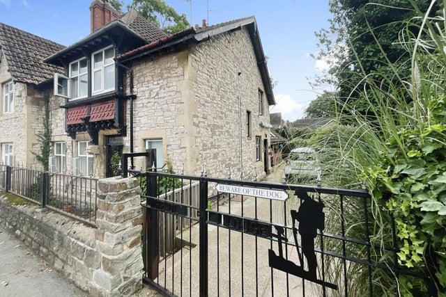 A view of the front of the historic cottage, with driveway parking.