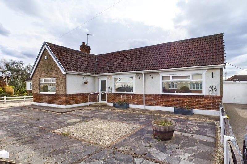 Paved front garden with boundary fence and driveway providin of road parking  and access to the garage