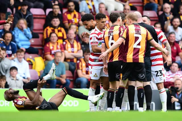 Bradford's Emmuanuel Osadebe after the challenge from Doncaster's Liam Ravenhill.