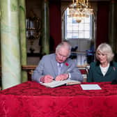 King Charles III and Camilla, Queen Consort, sign the visitor book as Donaster becomes a city
