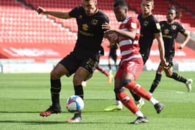 Debutant Rayhaan Tulloch tussles with MK Dons’ Warren O'Hora