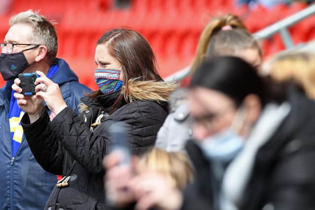 A Dons fan captures the moment on camera. Photo: Andrew Roe/AHPIX LTD
