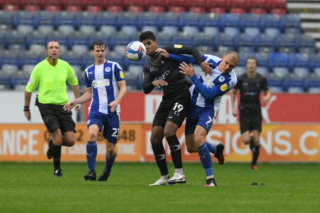 Tyreece John-Jules tussles with Wigan's Kal Naismith. Picture: Howard Roe/AHPIX