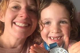 Rebecca Snape with her duaghter Grace who is holding the 100 mile medal.