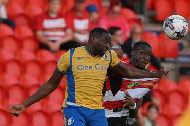 Doncaster Rovers defender Joseph Olowu challenges Mansfield Town's Lucas Akins for the ball.