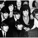 The Beatles surrounded by female admirers on one of their visits to Doncaster .