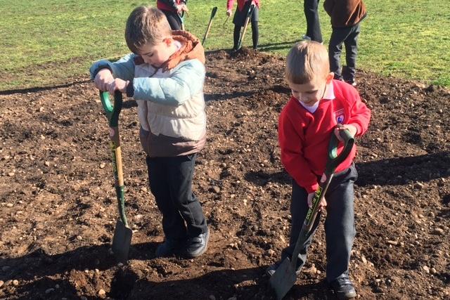 Children break the ground ready to get planting