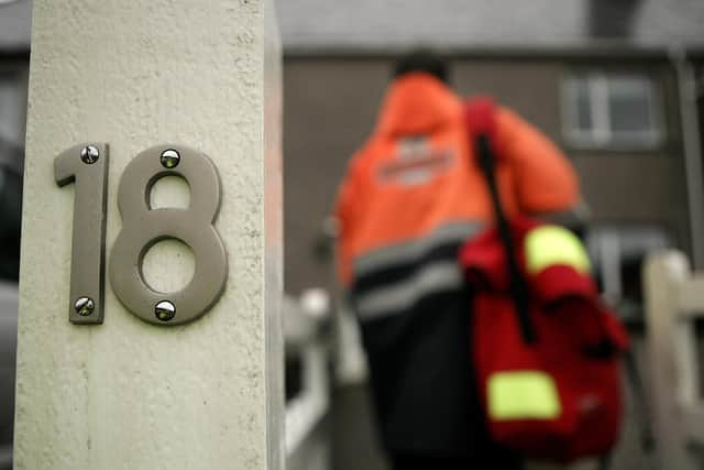 STORNOWAY, UNITED KINGDOM - NOVEMBER 30:  In this photo illustration postman Leslie Guy arrives at a local address on his round in Stornoway on the island of Lewis, Scotland on November 30, 2006. Royal Mail's 190,000 full time and part time staff handle 83 million items of post a day in the United Kingdom. In the lead up to Christmas the busiest day of the year is expected to be December 11 -  with Royal Mail handling almost 120 million items.  (Photo by Peter Macdiarmid/Getty Images)