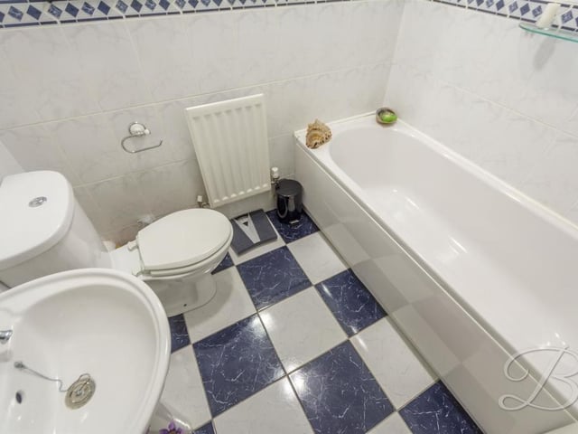 The main bathroom can be found upstairs. It comprises a panelled bath, low-flush WC, pedestal sink, full height tiling and central heating radiator.
