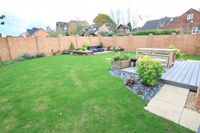 A large and enclosed rear garden with seating areas.