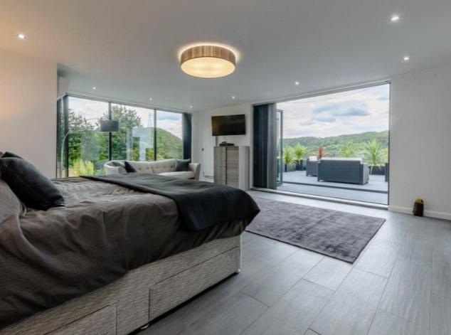 The impressive master suite boasts a walk-in wardrobe, sitting area, en-suite bathroom, and access to an outdoor terrace with far reaching views.