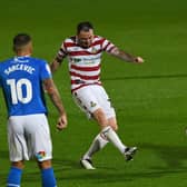 Lee Tomlin fires a shot towards goal against Stockport County.