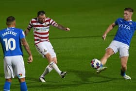 Lee Tomlin fires a shot towards goal against Stockport County.