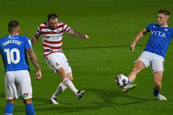 Lee Tomlin fires a shot towards goal against Stockport County.