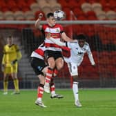 Owen Bailey wins a header for Doncaster Rovers in their defeat to Salford City.