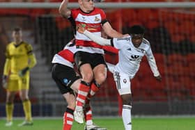 Owen Bailey wins a header for Doncaster Rovers in their defeat to Salford City.