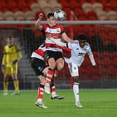 Owen Bailey wins a header for Doncaster Rovers in their defeat to Salford City.