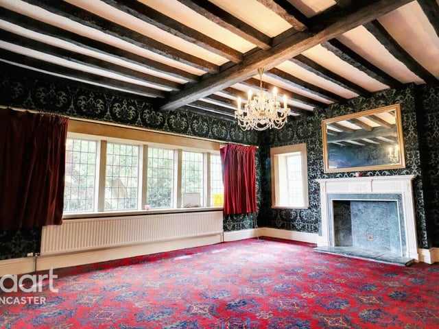 A beamed reception room with feature fireplace.