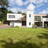 Sedum House sits back from Dore Road - oak intercom-operated gates open to the front of the property, where there is a block-paved driveway with mature trees, shrubs, and exterior lighting.