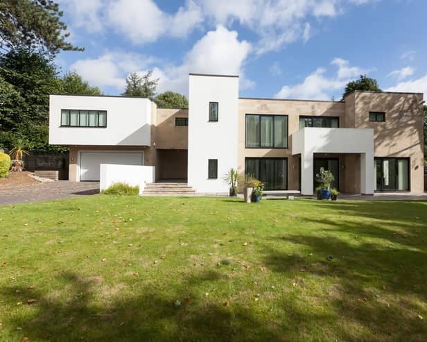 Sedum House sits back from Dore Road - oak intercom-operated gates open to the front of the property, where there is a block-paved driveway with mature trees, shrubs, and exterior lighting.