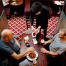 Customers are pictured being served a meal at a Wetherspoon pub. The chain has launched a deal called Stay Out to Help Out. Picture: Tolga Akmen/AFP via Getty Images.