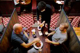 Customers are pictured being served a meal at a Wetherspoon pub. The chain has launched a deal called Stay Out to Help Out. Picture: Tolga Akmen/AFP via Getty Images.