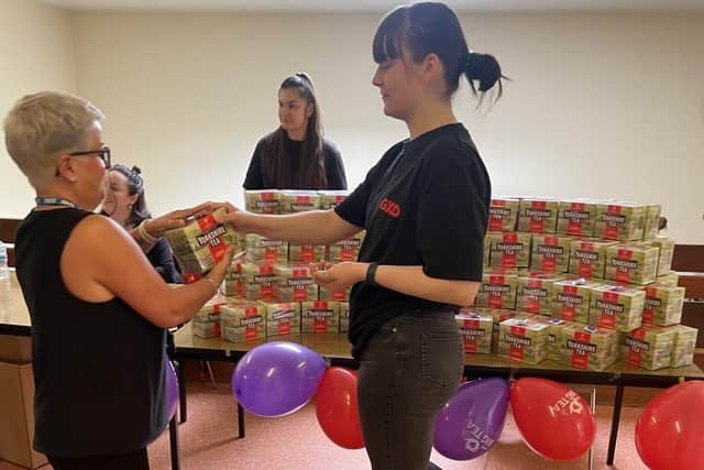 GXO volunteers help give out boxes of tea to staff.