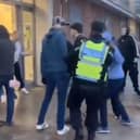 A lone police officer wades into the brawl outside Doncaster railway station.