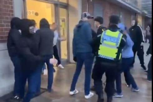A lone police officer wades into the brawl outside Doncaster railway station.