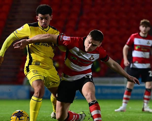 Doncaster Rovers' Owen Bailey battles for the ball against Burton Albion in the Bristol Street Motors Trophy.
