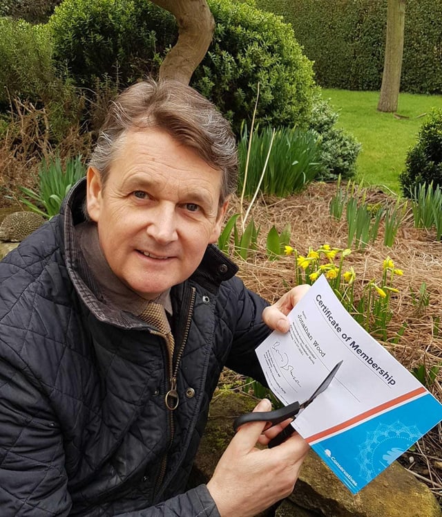 Councillor Jonathan Wood cuts up his Conservative Party membership