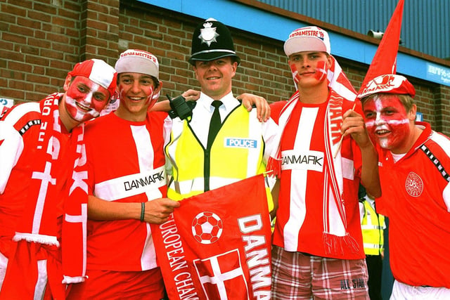 A Sheffield police officer poses for a photo with excited Danish fans outside Hillsborough.