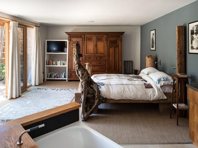The master bedroom, positioned at the far end of the lower floor, has an en-suite bathroom and access to the private courtyard.