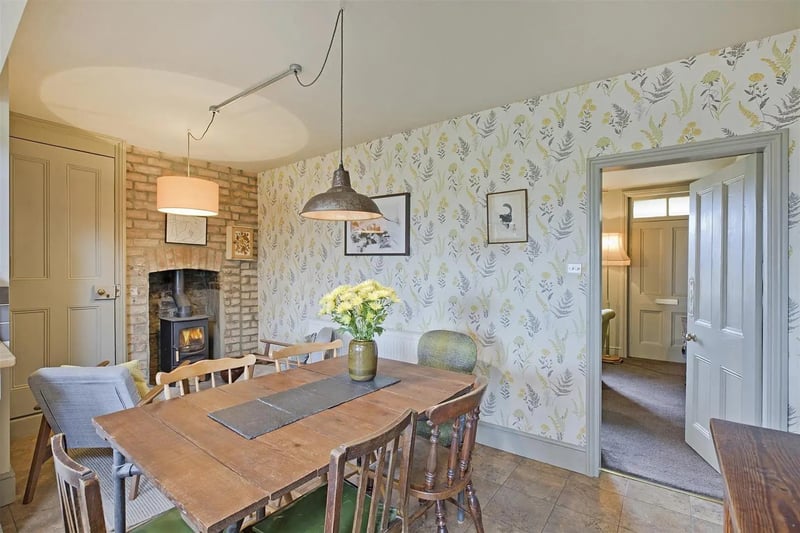 A spacious dining area with a warming stove in exposed brick surround.