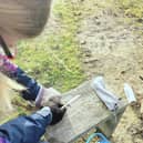 A pupil at Doncaster Forest School using the donated wood to craft.